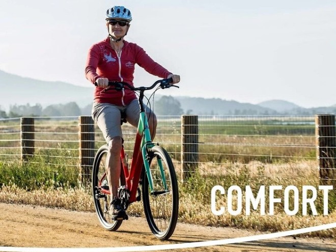Person in red shirt and helmet rides a bike on a rural path, with 'COMFORT' text overlay.
